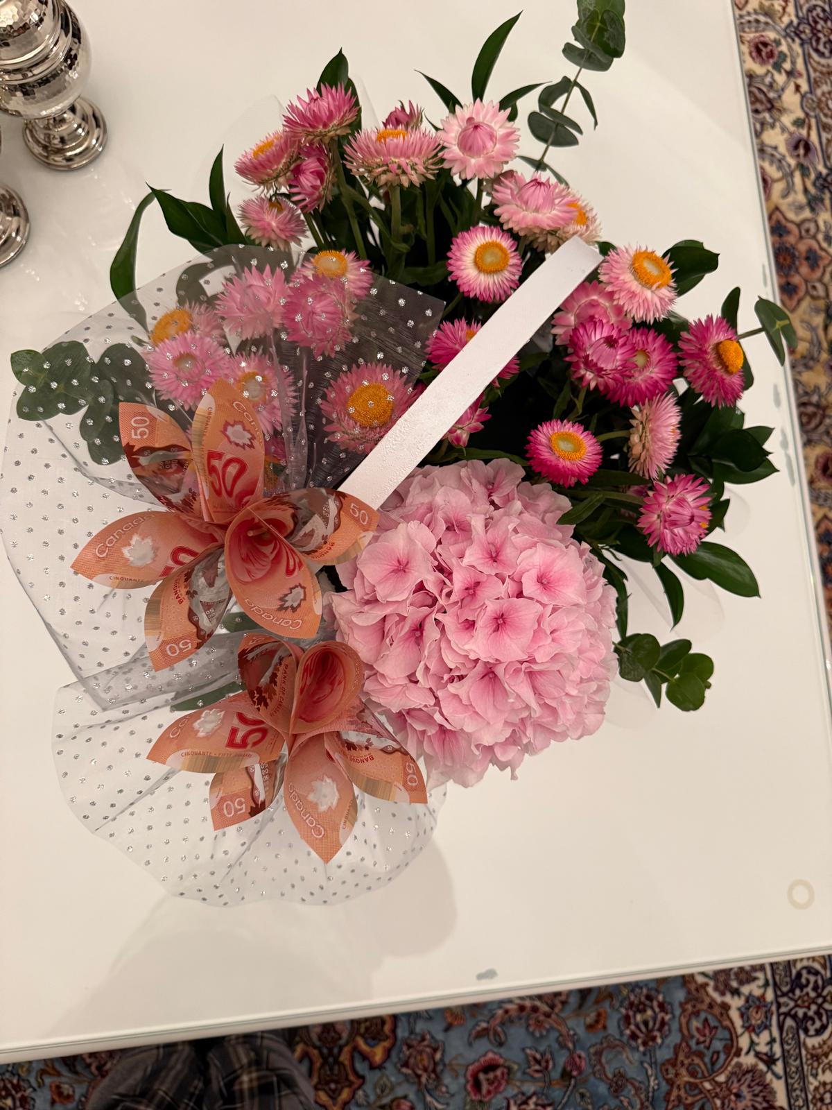 Pink hydrangea and bright pink flowers with greenery, folded banknote blooms and sheer dotted wrapping.